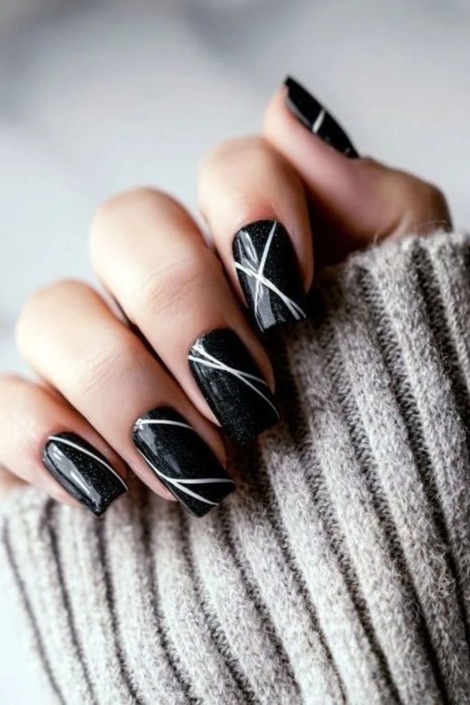 Curved arcs across matte black nails