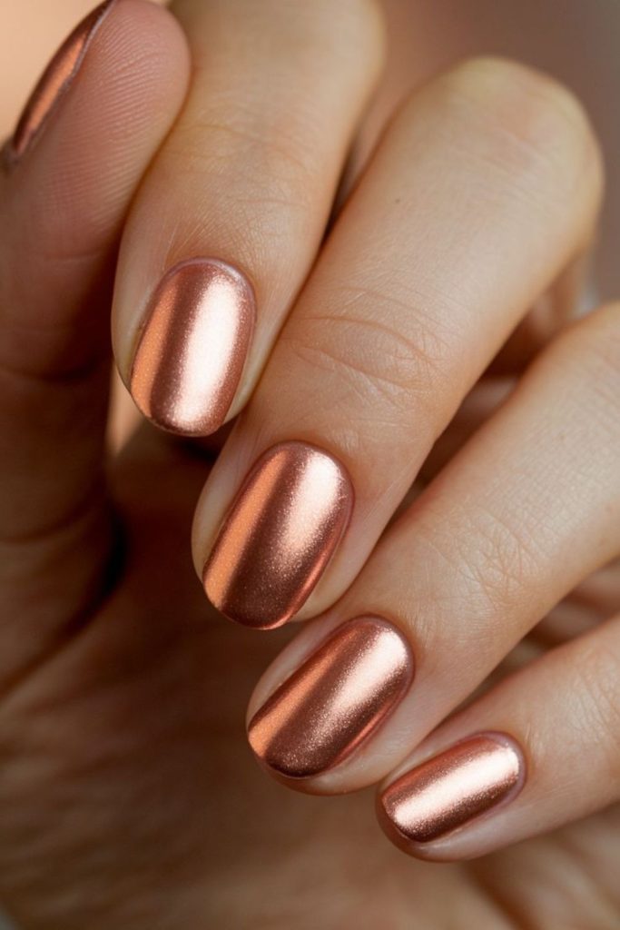 Pink metallic nails with soft glow.