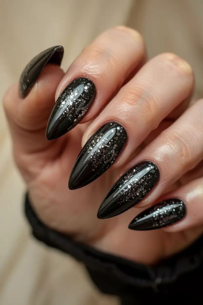 Silver specks scattered on black nails