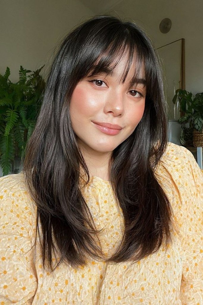 Rounded arc bangs brushing cheek contours