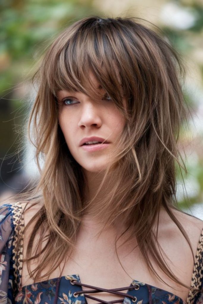 Sunlit layered wolf cut dramatic.