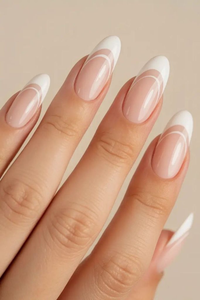 Creamy white arcs on nude nails.
