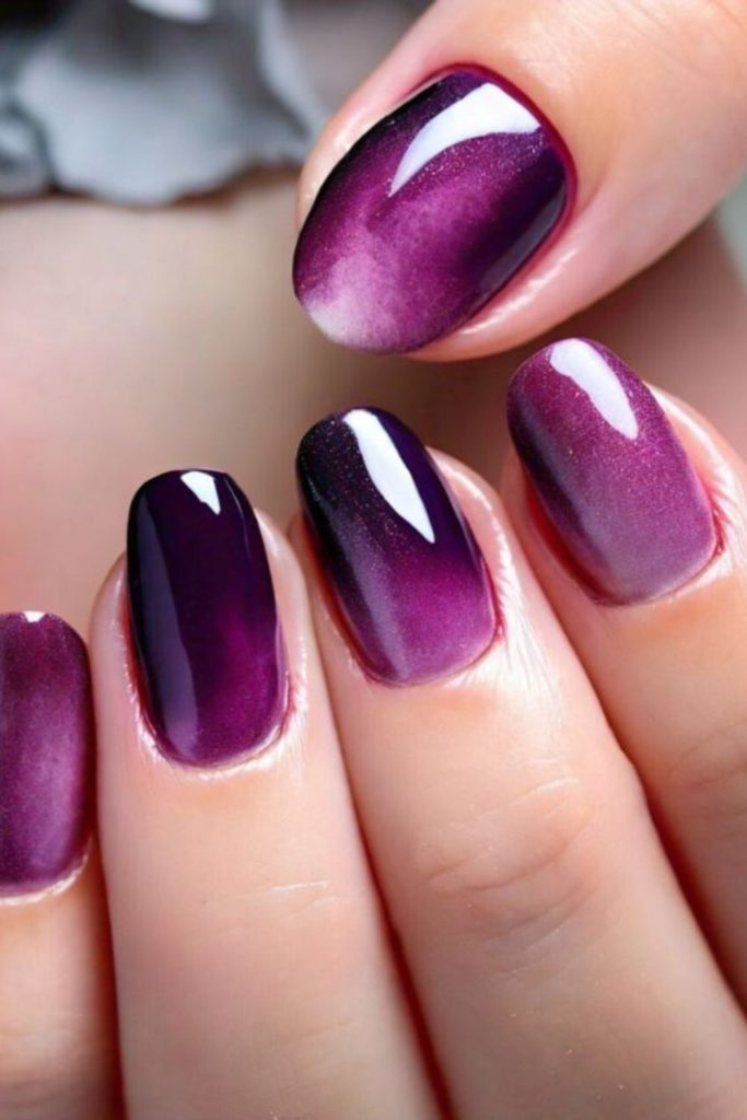 Plum smoke drifts across matte nails