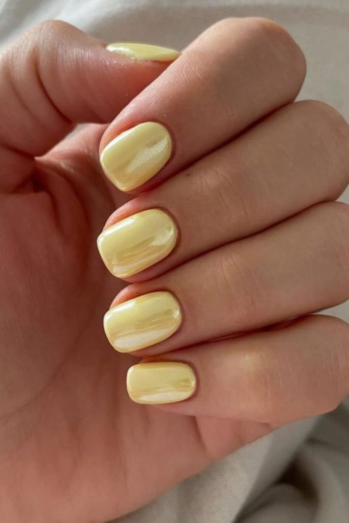 Pastel yellow glossy nails.
