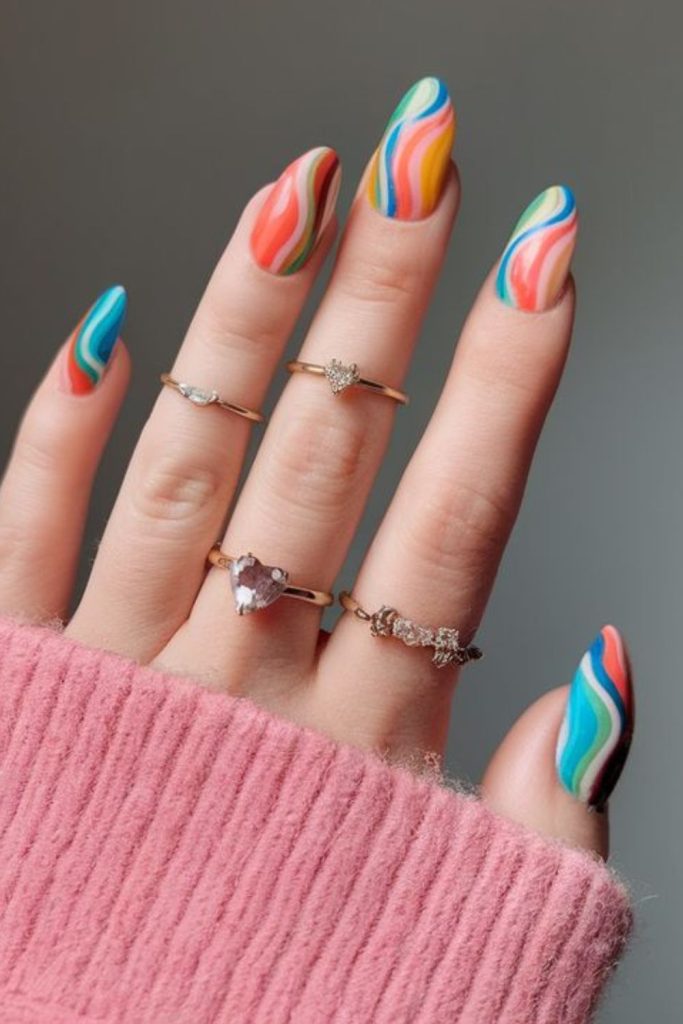 Playful pastel swirl nails with sprinkles.