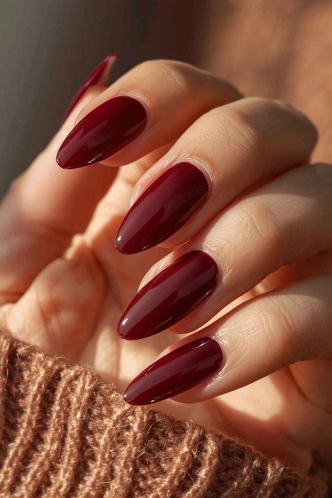 Deep crimson glossy nails, moody elegance.
