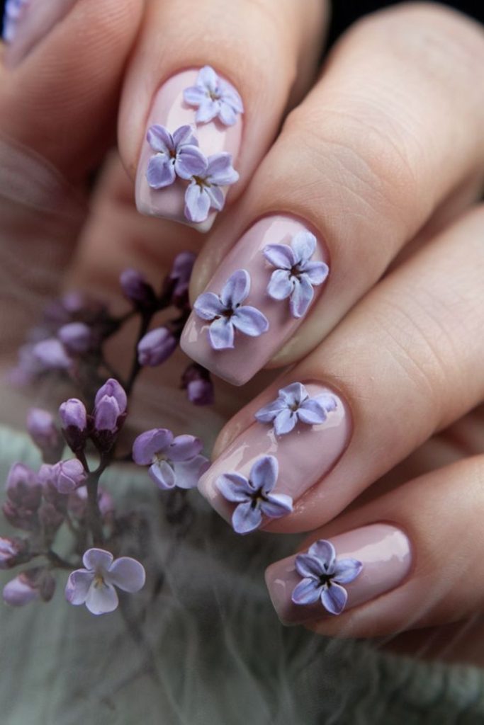 Blush nails with pale violet flowers