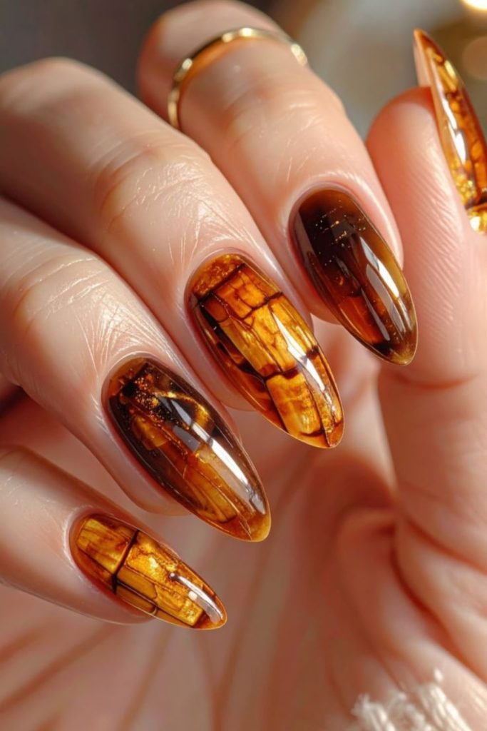 Amber nails with flowing glossy streaks.
