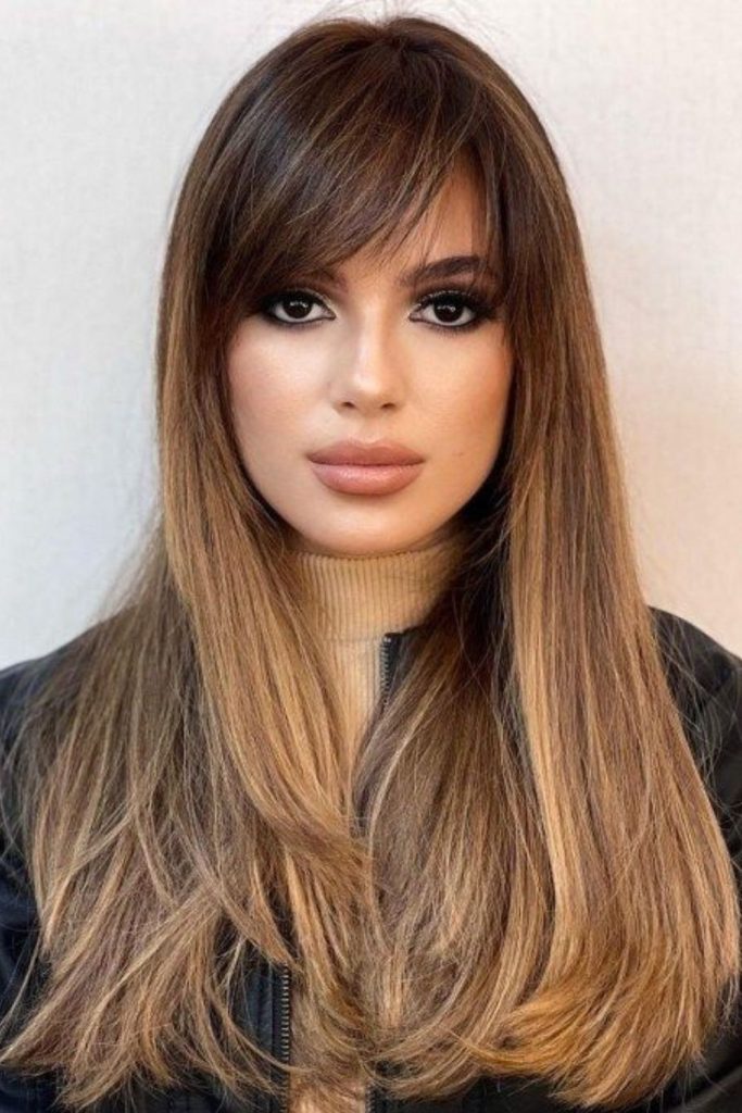 Angled layered bangs shaping oval face