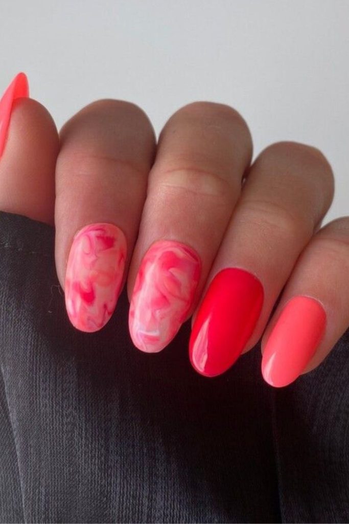 Coral lava nails with glossy streaks.
