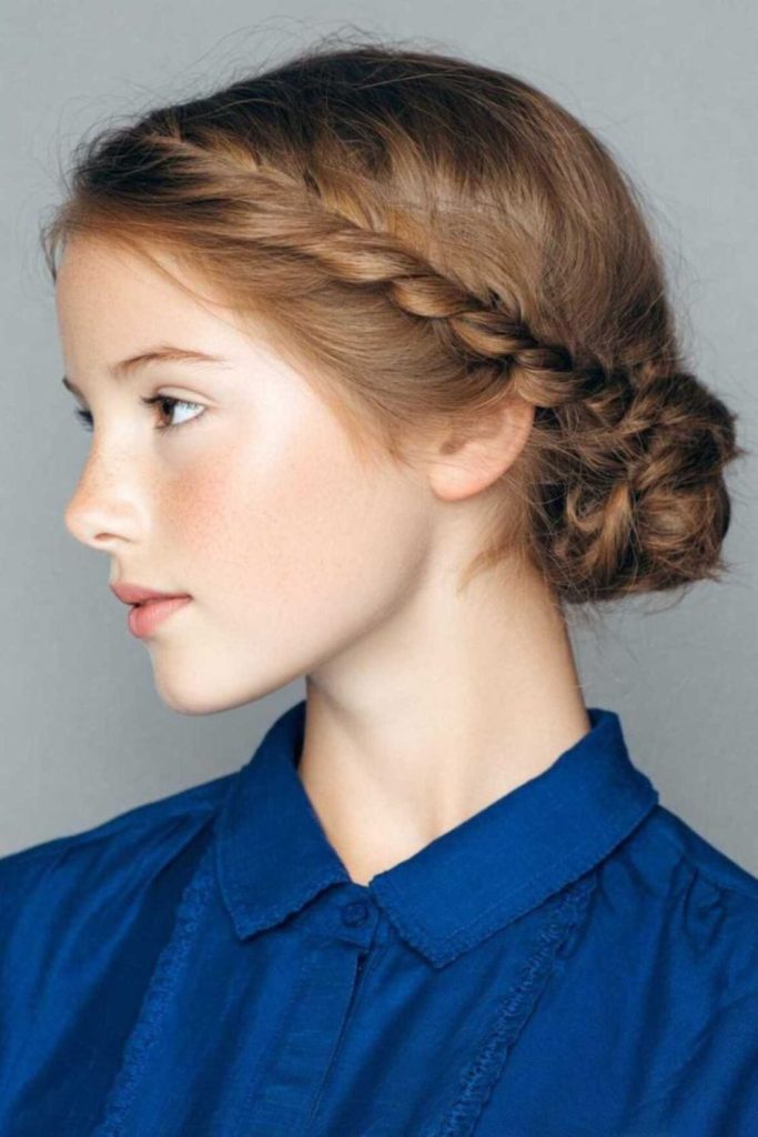 Low messy braided bun with loose tendrils