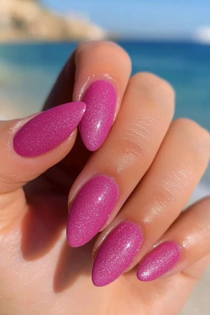 Neon rose nails with reflective glitter.