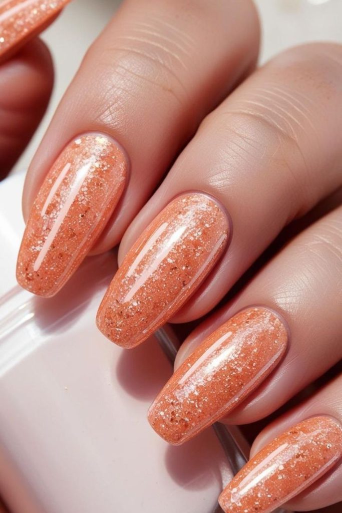 Peach nails with golden flecks