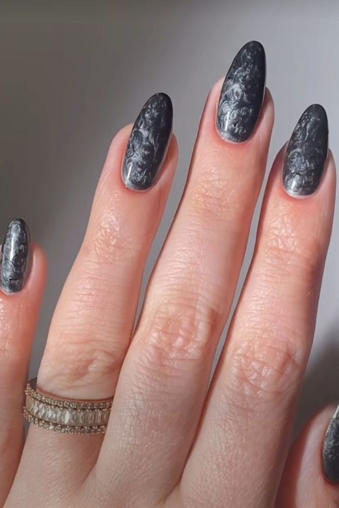 Grey nails etched with tiny scripts