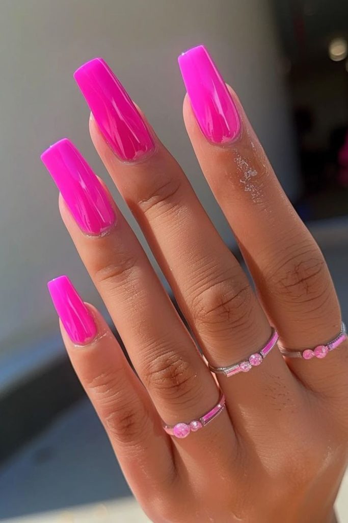 Electric pink nails with dynamic sparkle.