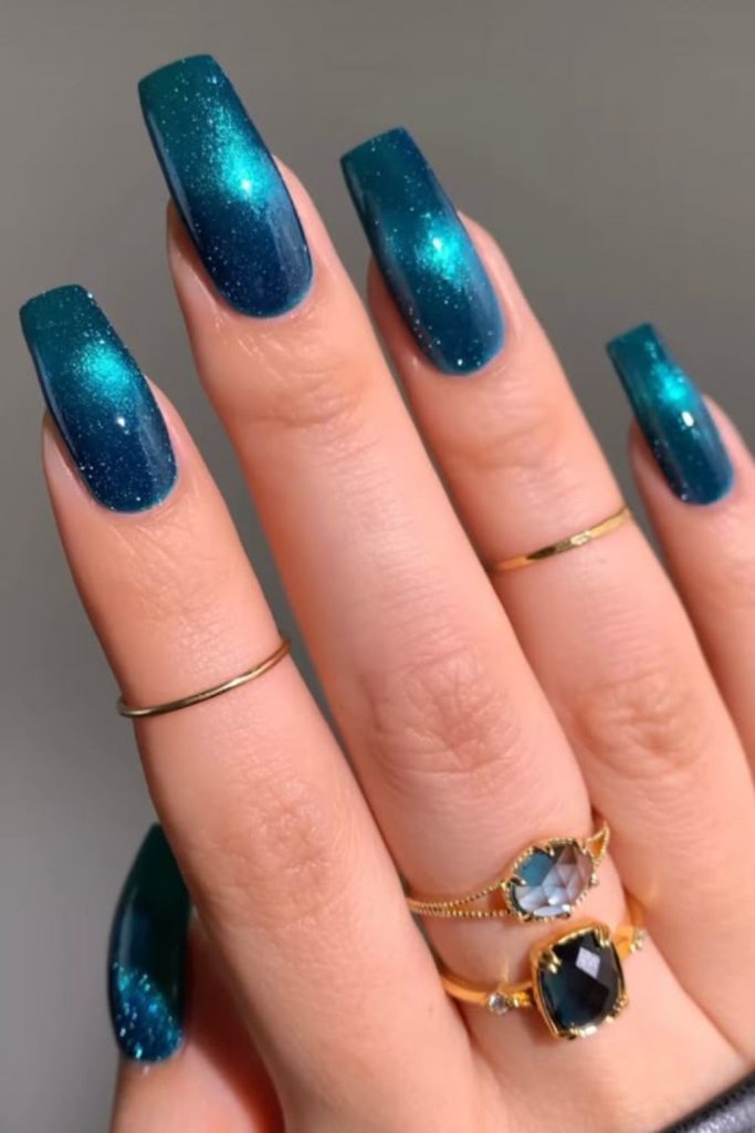 Teal nails with metallic wave accents.