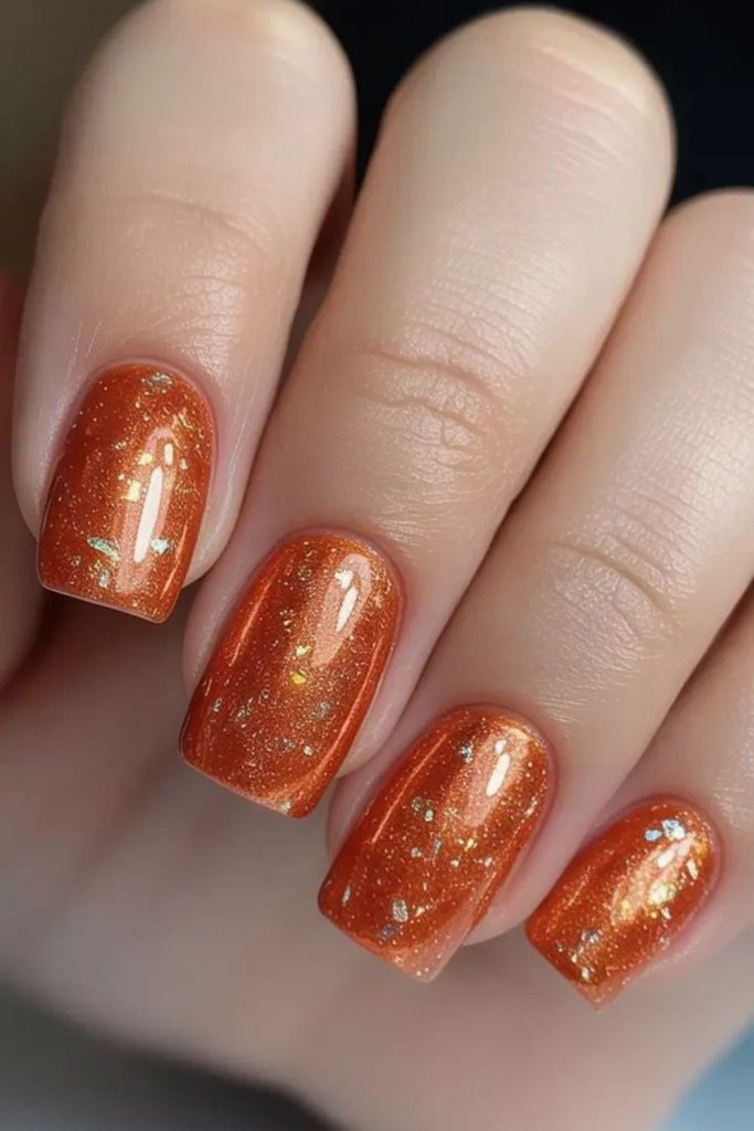 Bright orange nails with gold spark