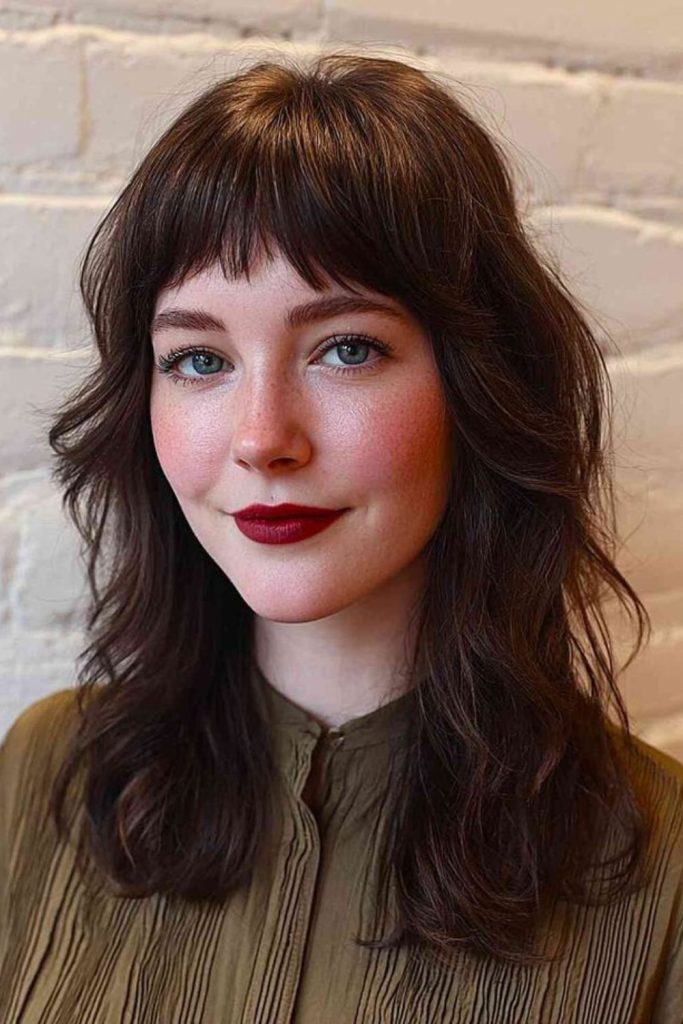 Tiny wispy bangs hovering above brow