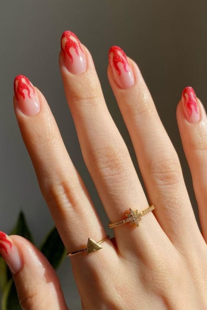 Crimson flame tips on nude nails.
