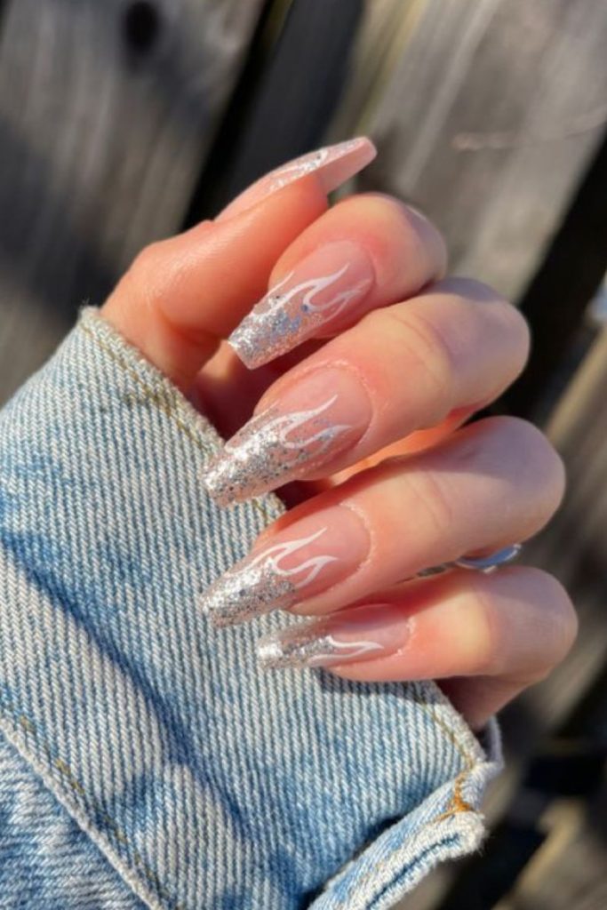 Rhinestone flame design on nude nails.