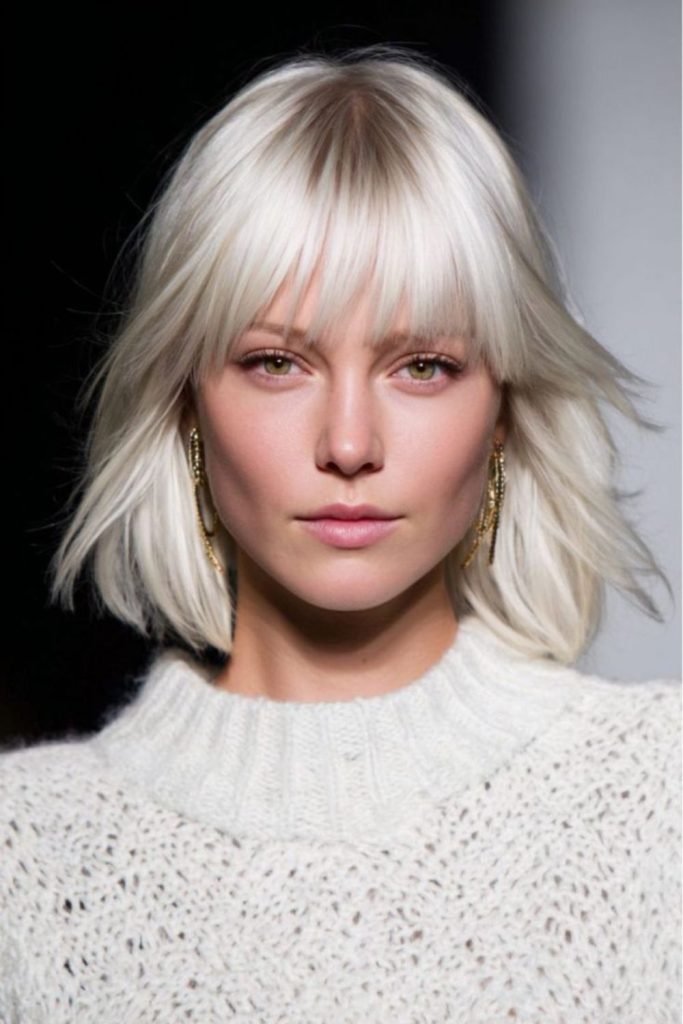 Blunt platinum bangs with flicked underlayers