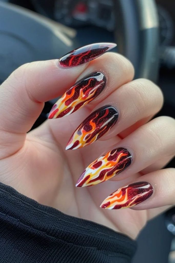 Gold flames on burgundy nails.