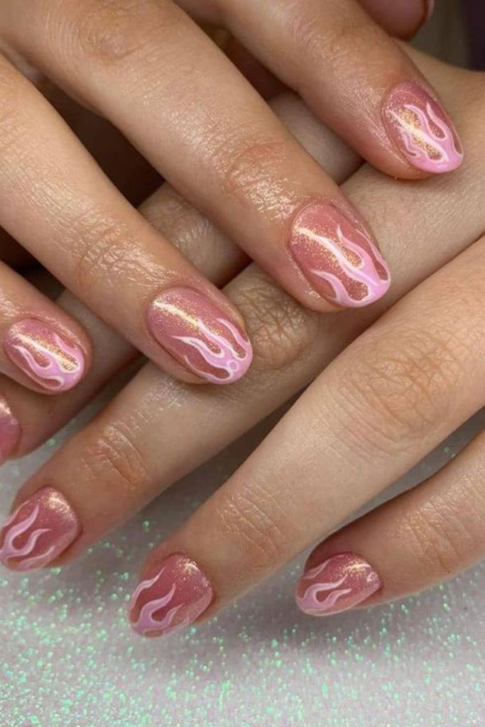 Rose gold flames on blush nails.