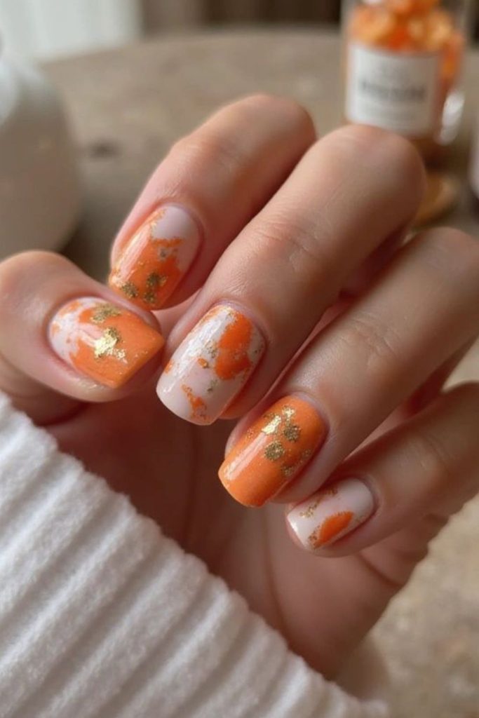 Gradient tangerine nails with hazy effect.