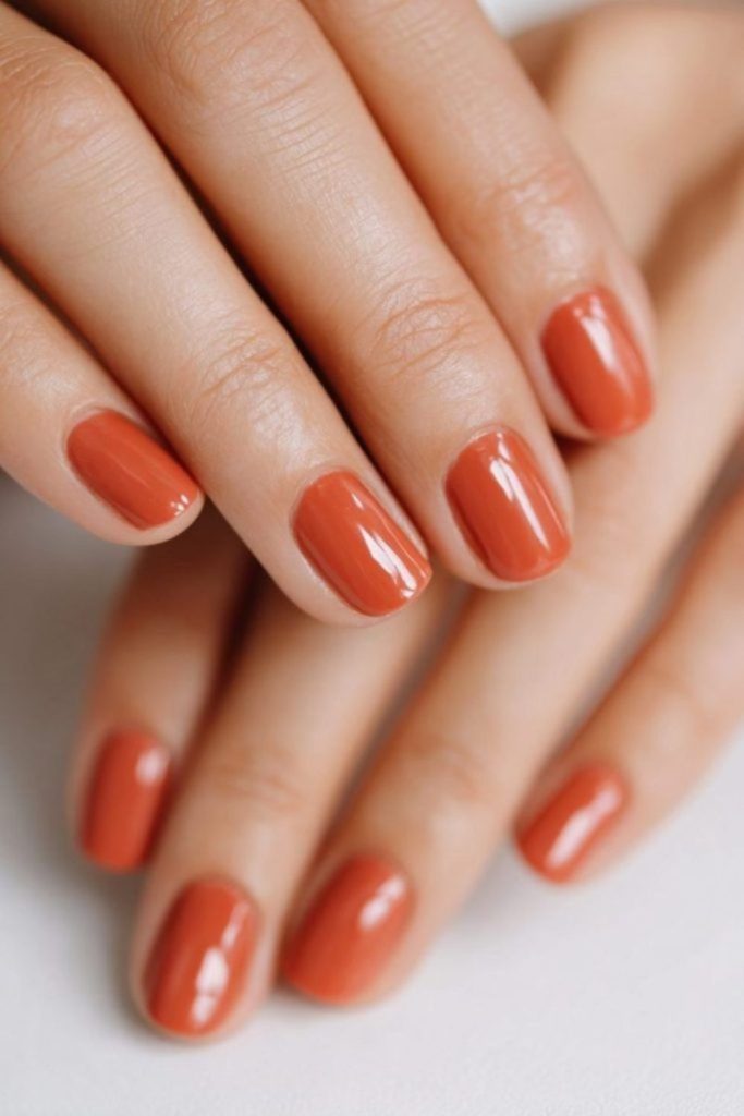 Bright orange nails with bold streaks.