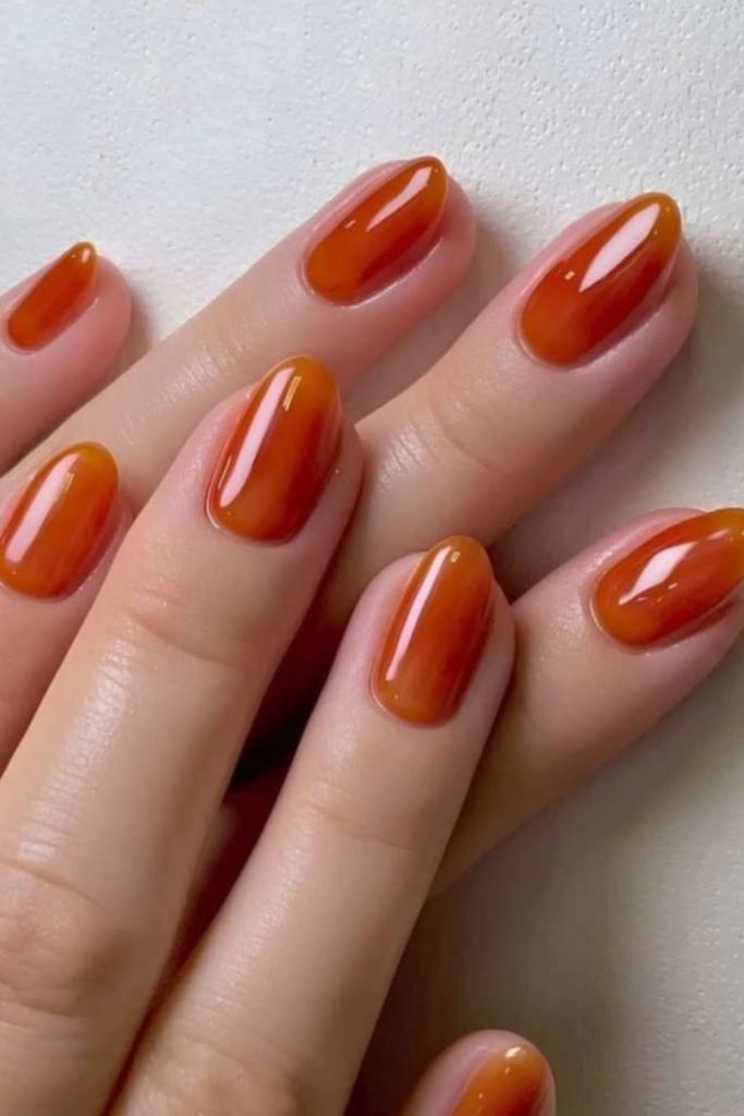 Amber petal brushstroke nails with glow.