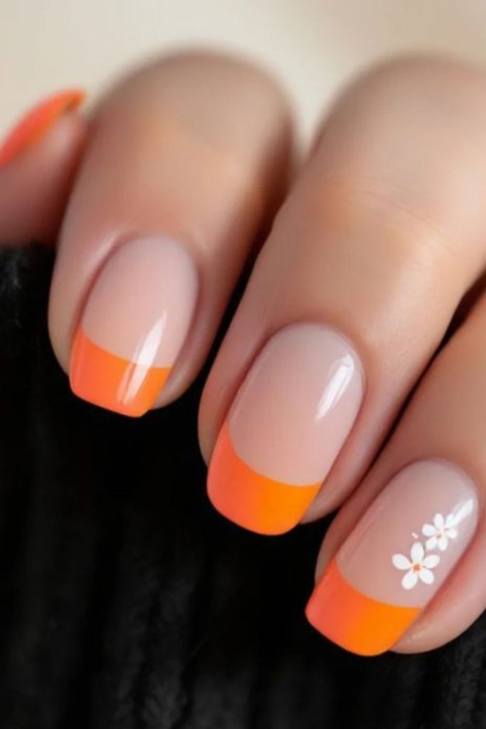 Coral orange French tip modern nails.