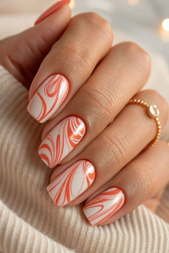 Peach and ember swirl glossy nails.
