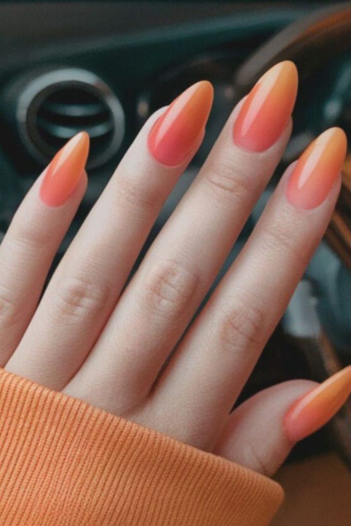 Sunset ombre orange gradient glossy nails.