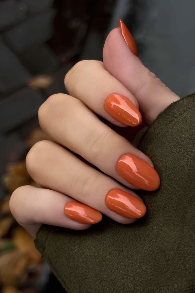 Matte tangerine nails with soft shimmer.