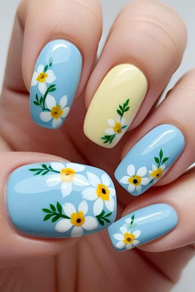 Blue nails with yellow floral sketch art.