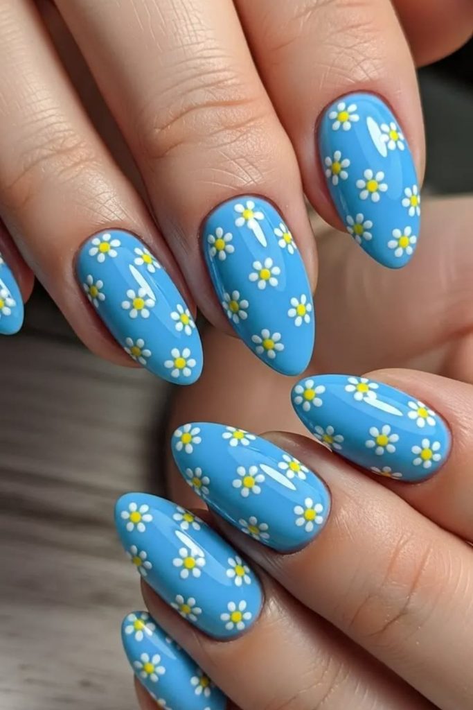 Sky blue nails with yellow daisy patterns.