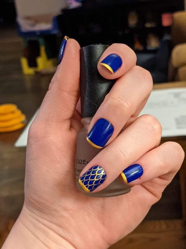 Blue nails with yellow royal crown accents.