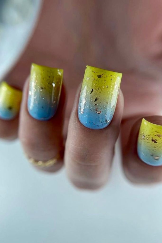 Sky blue nails with glowing yellow tips.