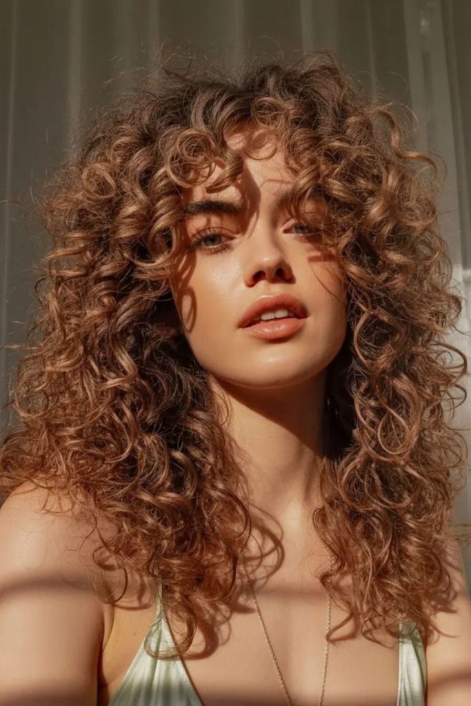 Warm cinnamon toned spiral curls forming curtain style