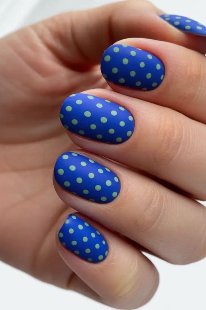 Blue nails with yellow confetti style dots.