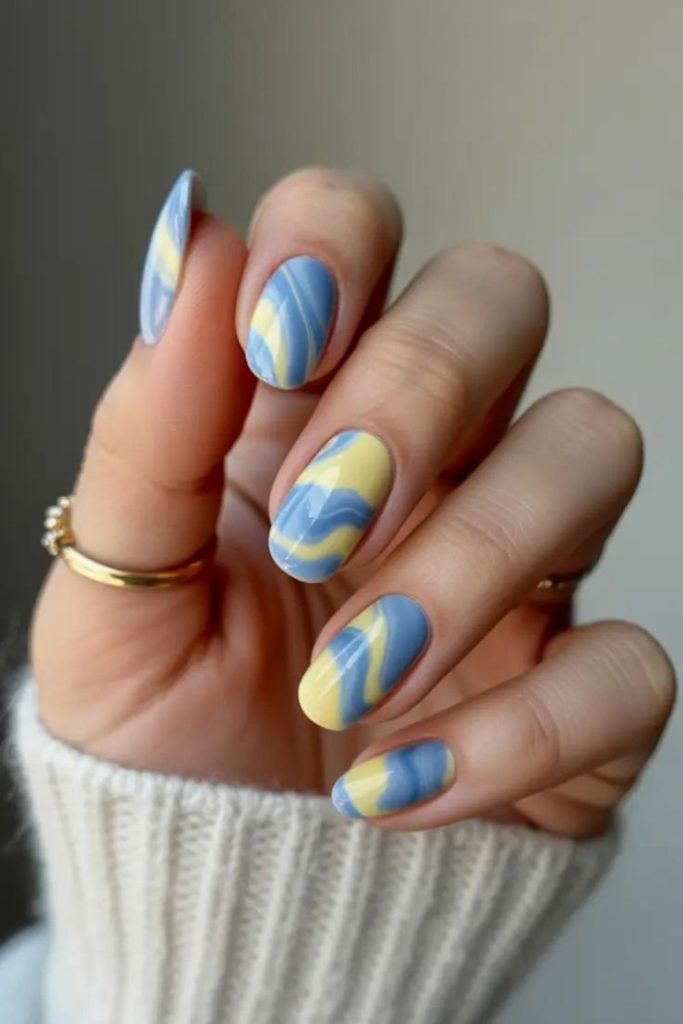Blue nails with yellow ribbon flow design.