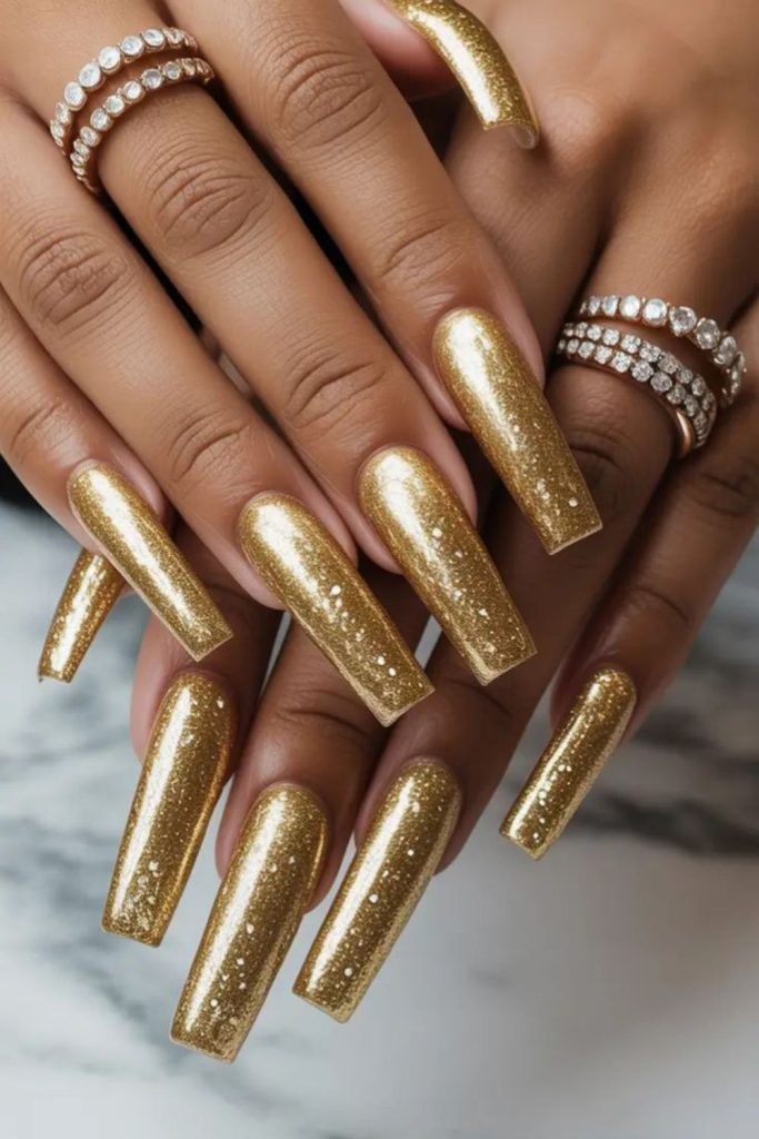 Golden glitter coffin glam nails.