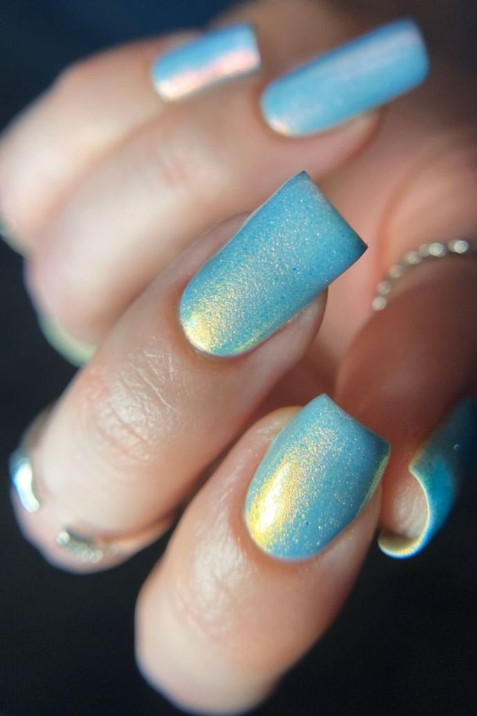 Frozen blue nails with yellow galaxy sparkle.
