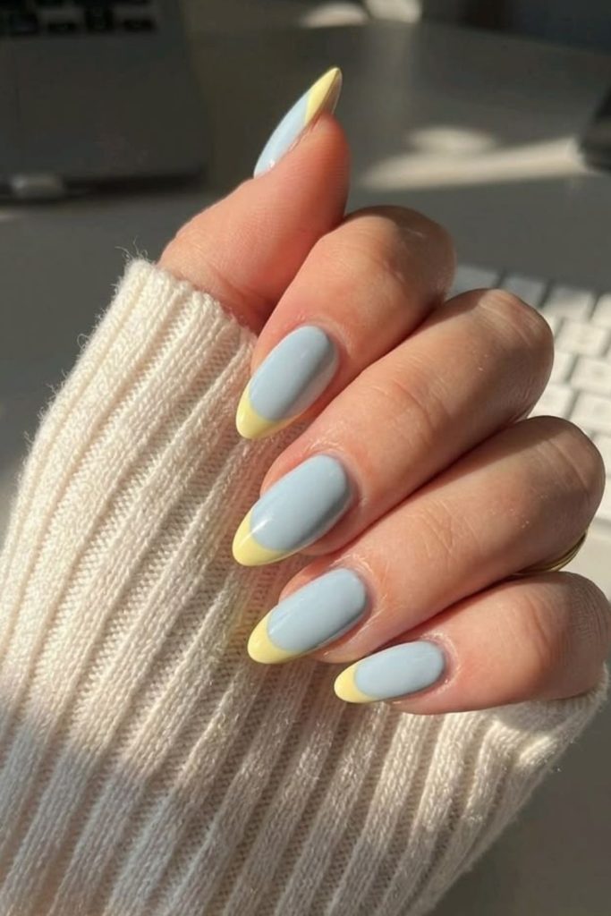 Blue nails with yellow wave french tips.