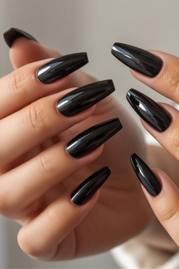 Glossy black coffin glam nails.