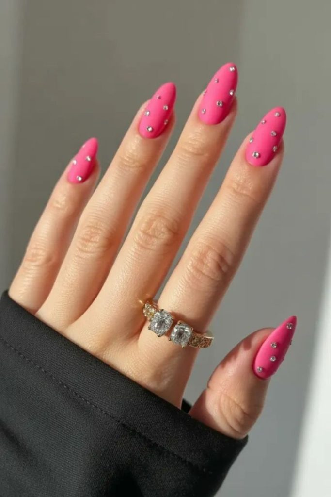 Bright pink gem baddie nails.