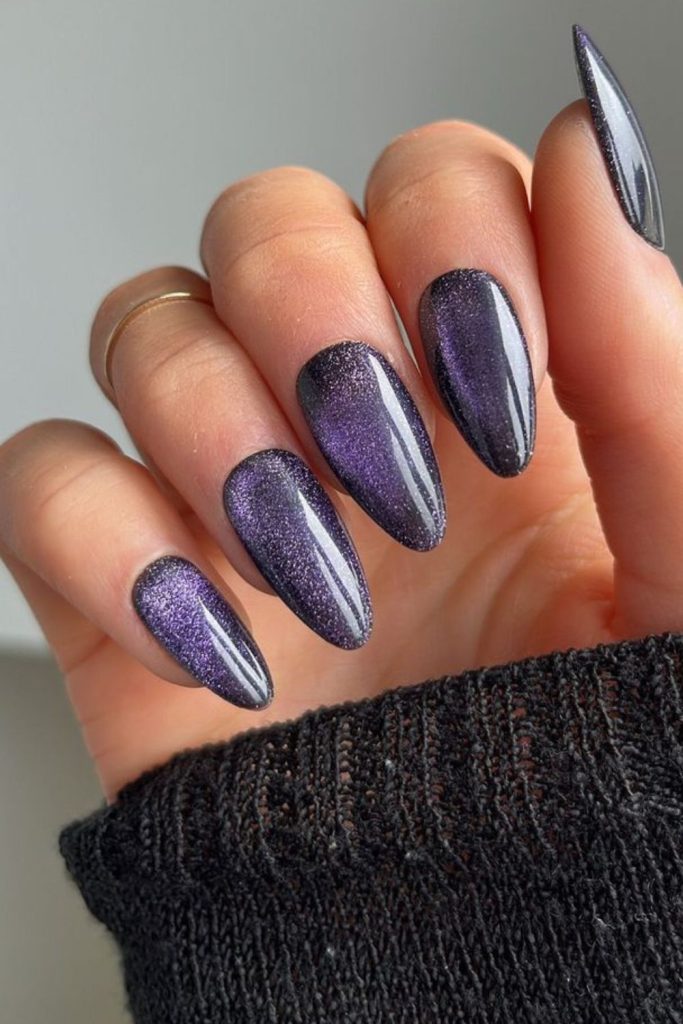 Glossy purple shimmer almond nails.