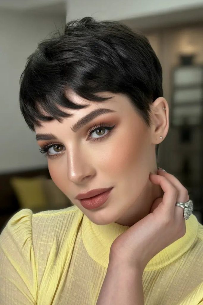 Jet black pixie cut with sharp uneven layers and glossy edgy finish.