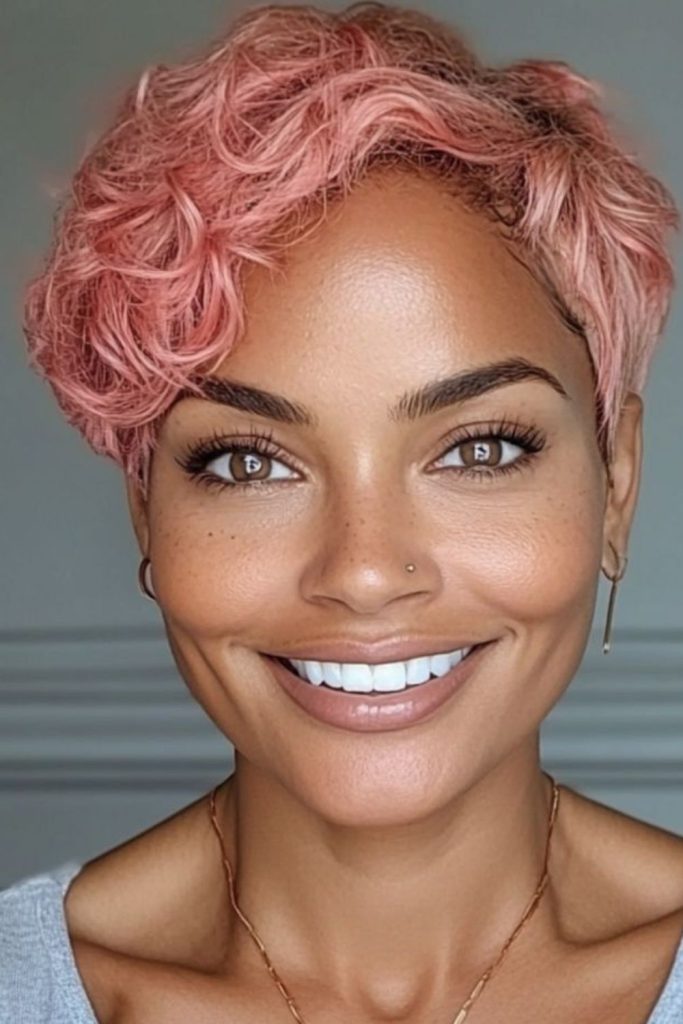 Pink toned pixie cut with soft pastel glow and delicate feminine layers.