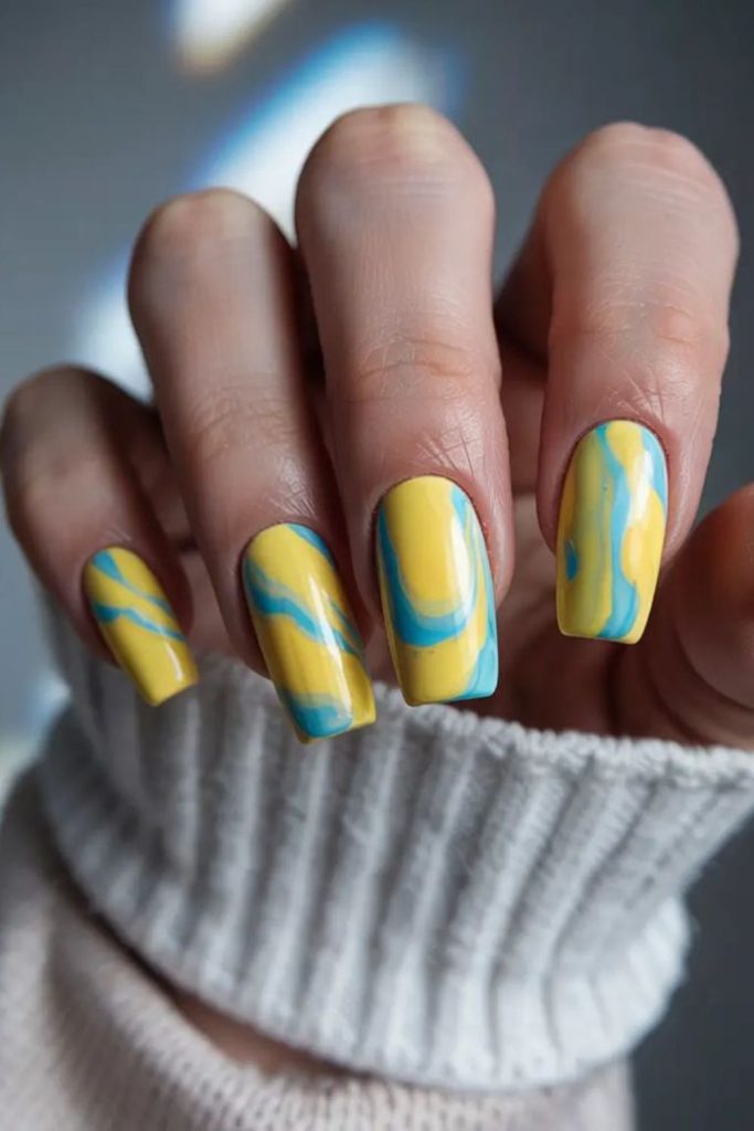 Marble blue nails with lemon yellow swirls.